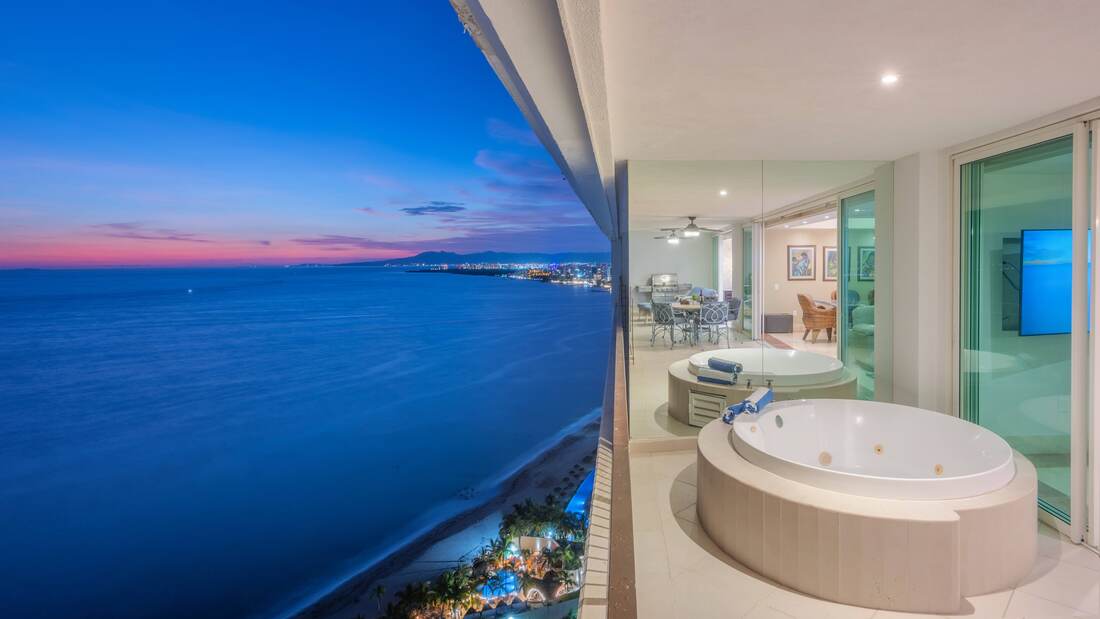 Private terrace jacuzzi overlooking the bay at dusk