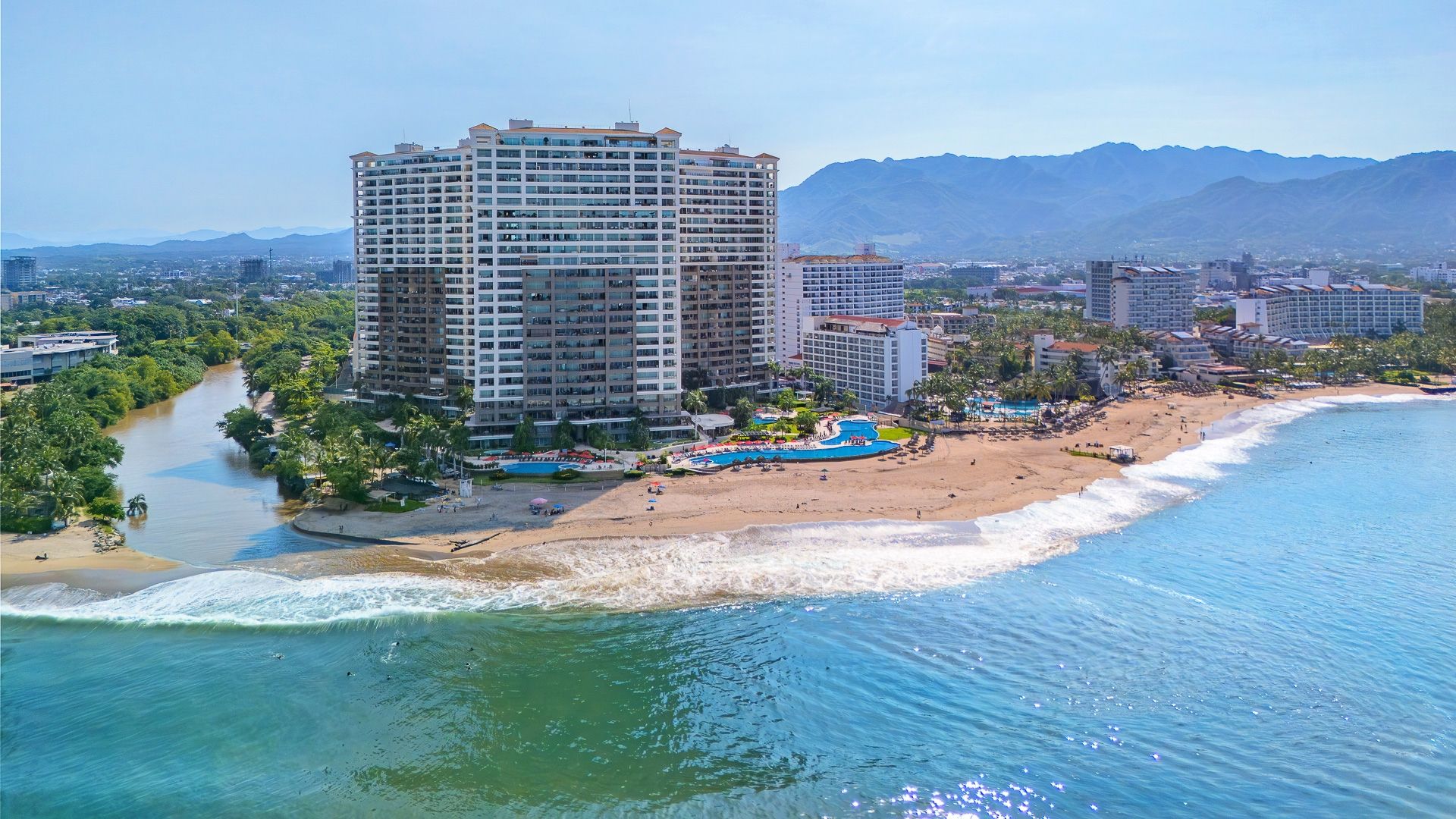 Aerial view of Grand Venetian on the beachfront in Puerto Vallarta's Hotel Zone, with Banderas Bay and the Sierra Madre beyond