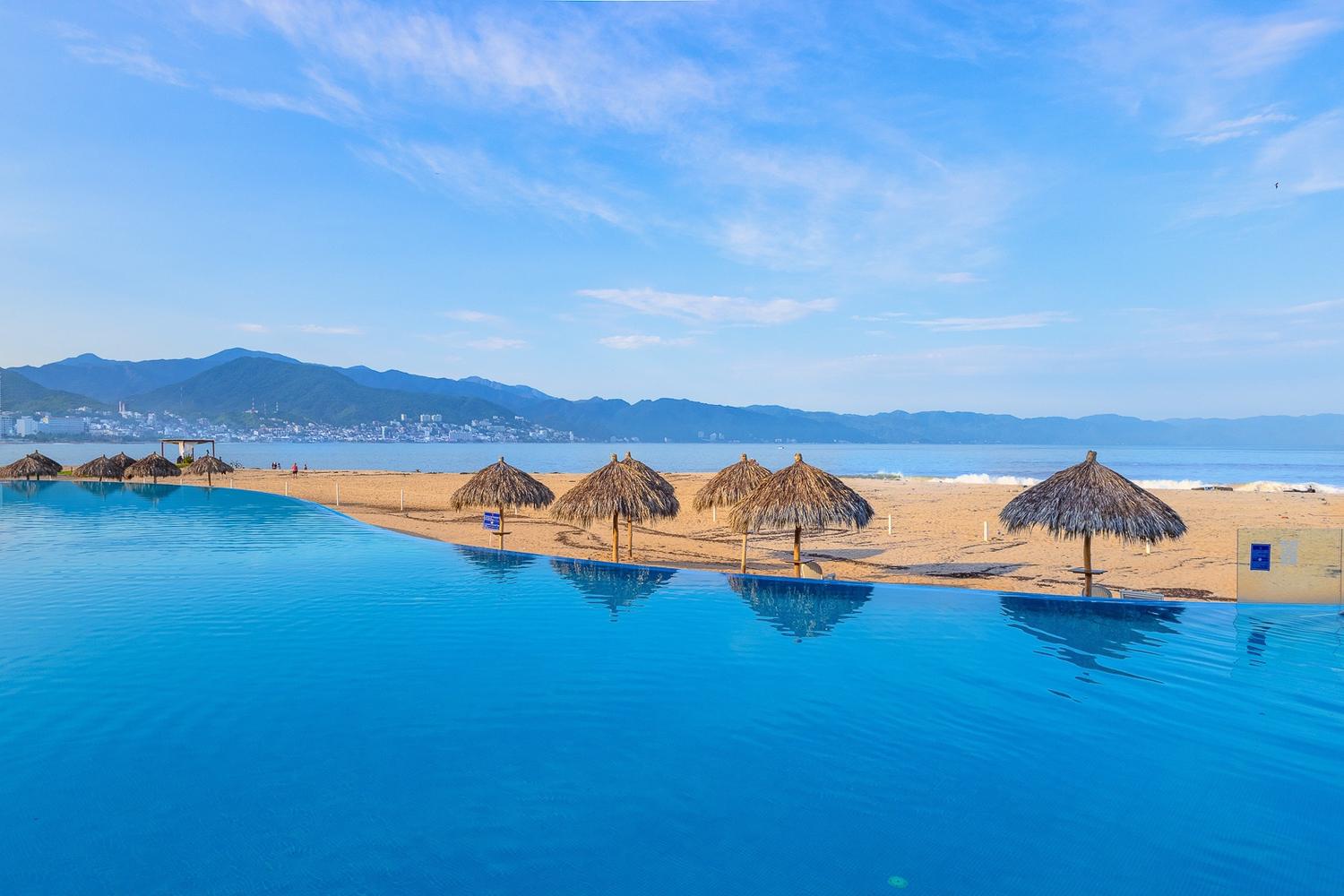 Infinity pool and palapas at the edge of the sand, Grand Venetian